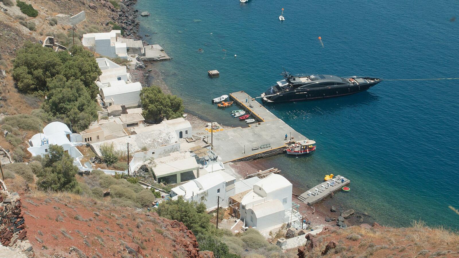 De kronkelende kustweg en het haventje Armeni onder Oia