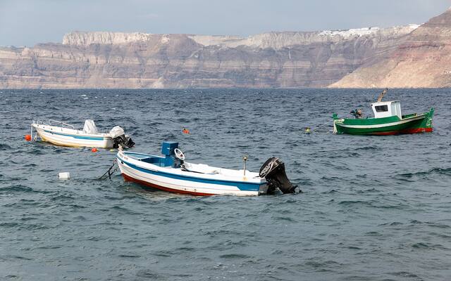 Bootjes in de caldera bij Akrotiri met de calderawand op de achtergrond