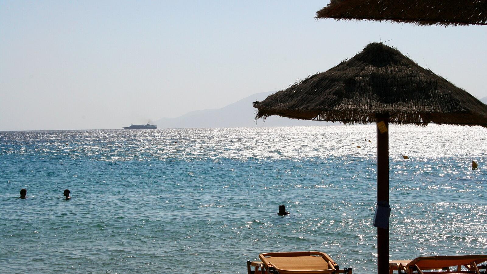 Rieten parasols op Mylopotas Beach op Ios met zicht op zee