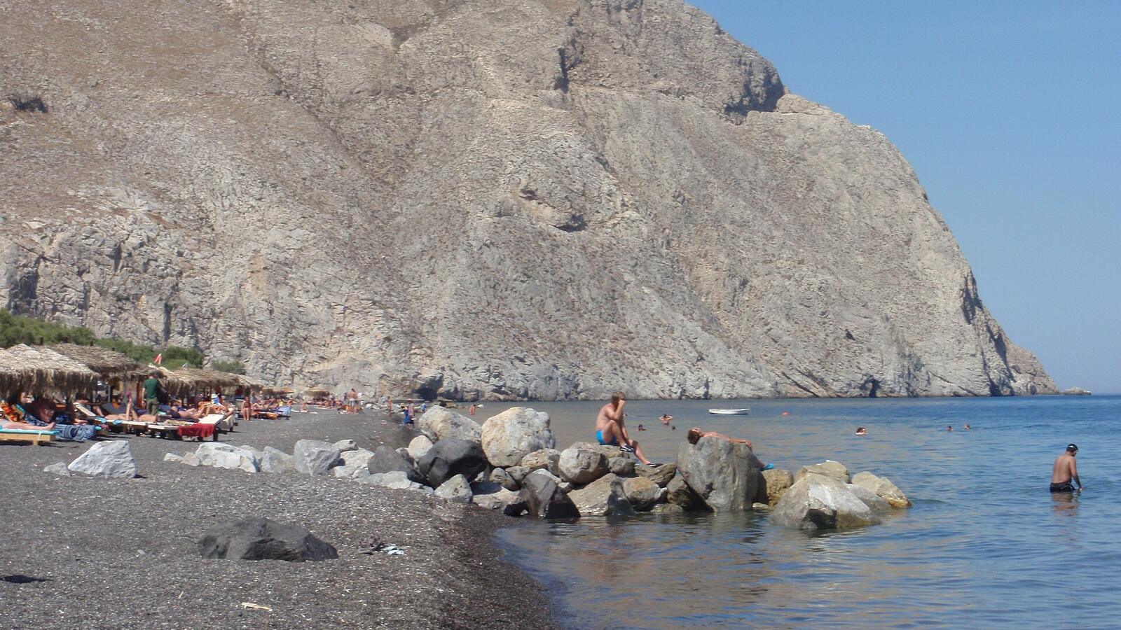 Perissa Beach met zwart zand en de berg Mesa Vouno op de achtergrond