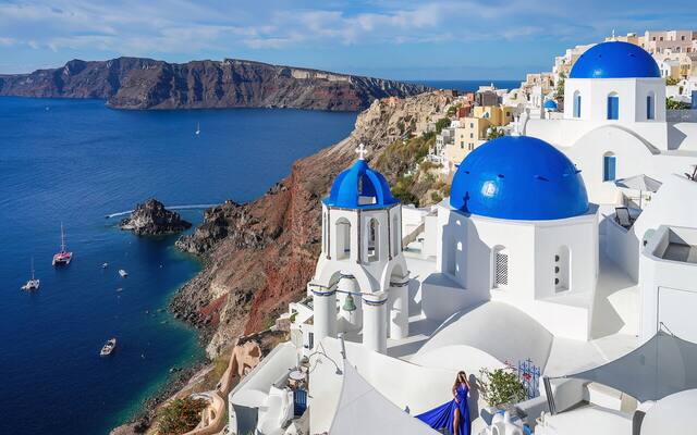 Drie blauwe koepels van kerken in Oia boven de caldera van Santorini