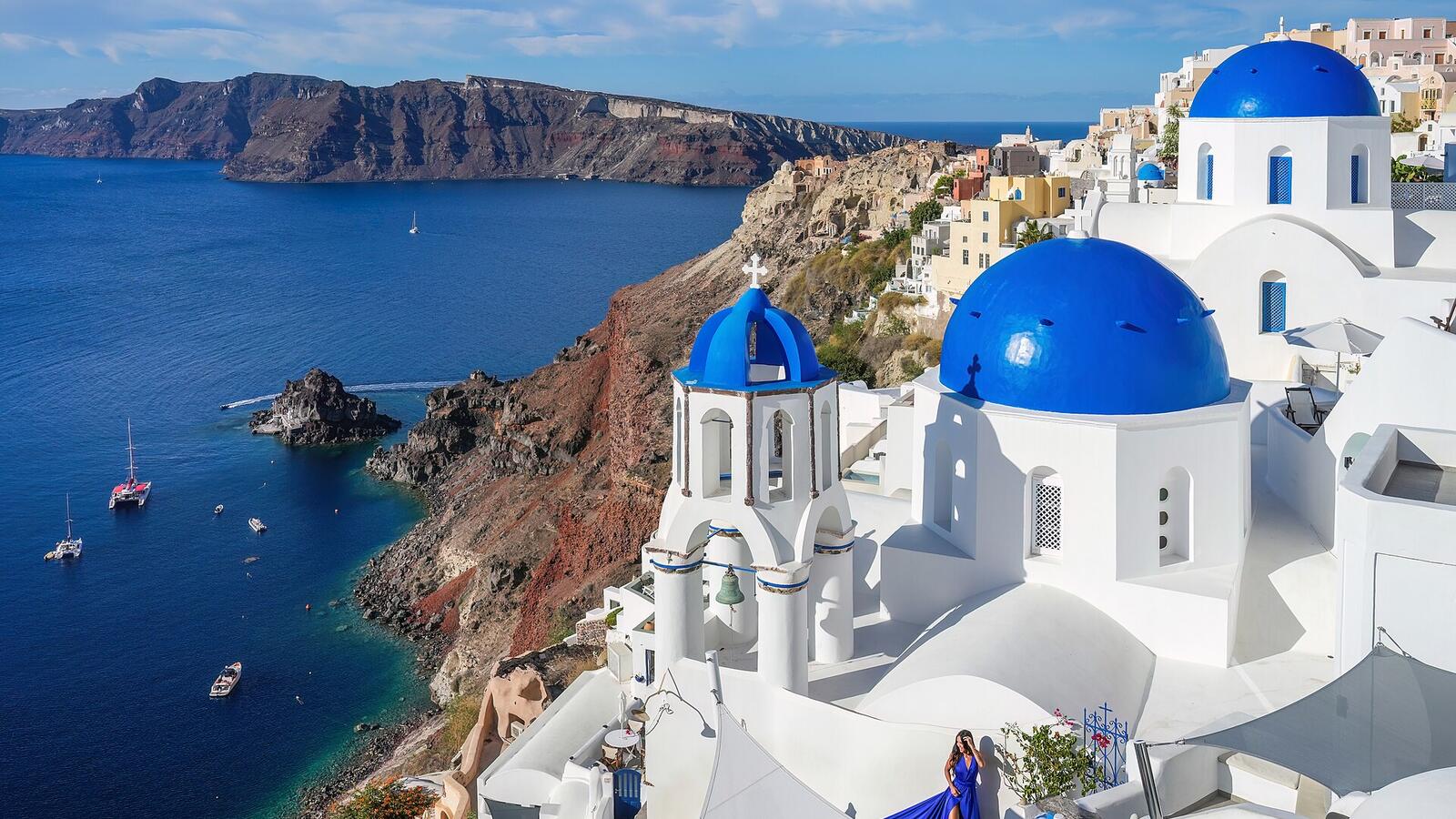 Drie blauwe koepels van kerken in Oia boven de caldera van Santorini