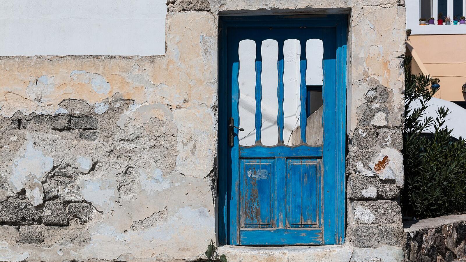 Blauwe houten deur in een oude muur in Pyrgos