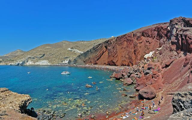 De Red Beach bij Akrotiri met rode kliffen, zwarte kiezels en helderblauw water
