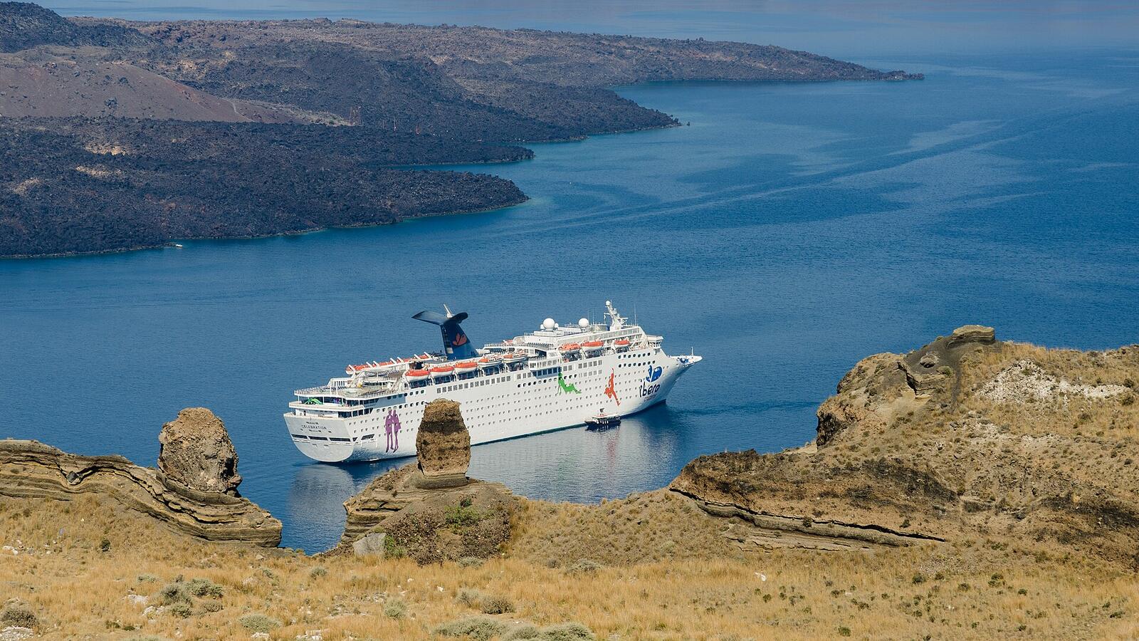 Een cruiseschip in de caldera van Santorini onder de kliffen