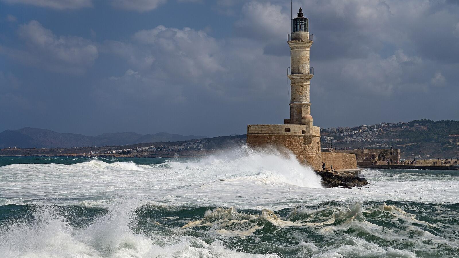 De vuurtoren van de Venetiaanse haven van Chania met golven