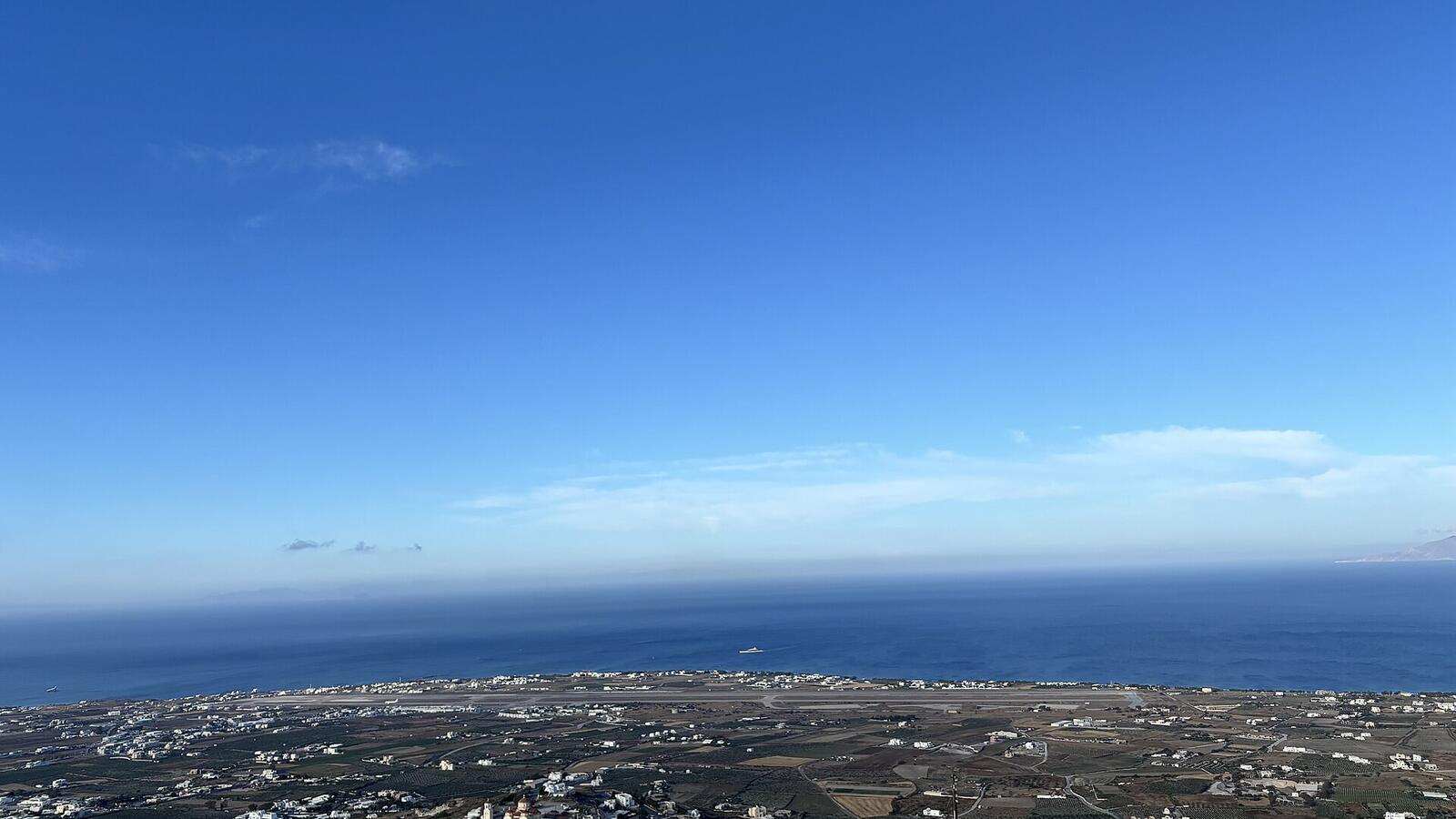 De luchthaven van Santorini gezien vanaf Pyrgos met de zee op de achtergrond