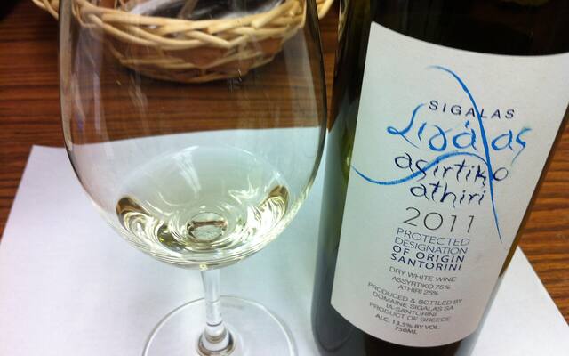 Een fles Santorini-wijn van assyrtiko en athiri met een glas witte wijn