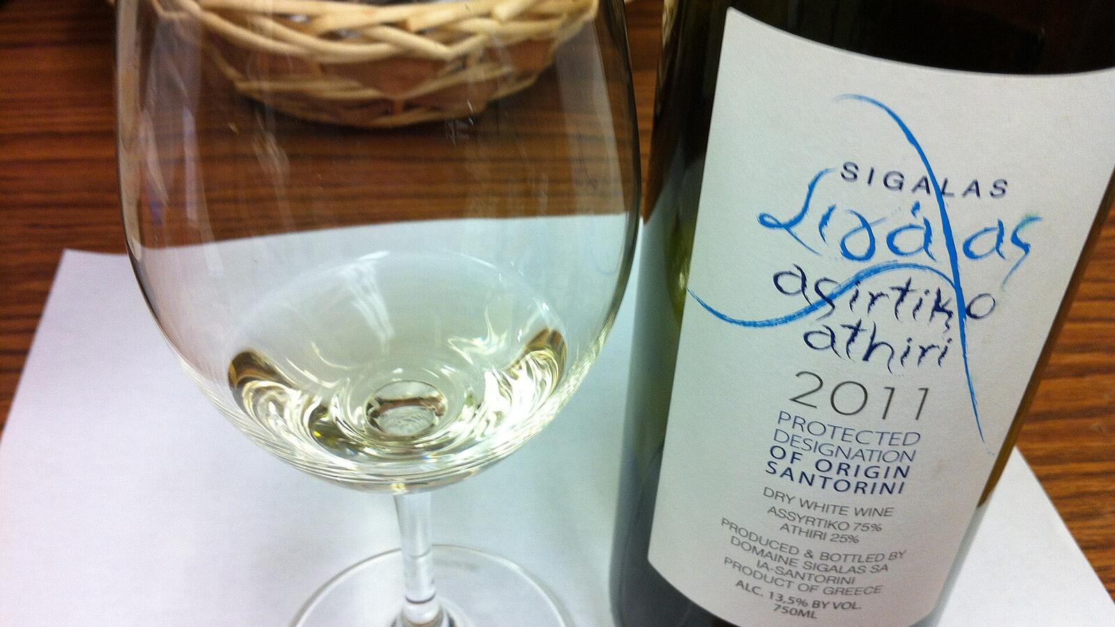 Een fles Santorini-wijn van assyrtiko en athiri met een glas witte wijn